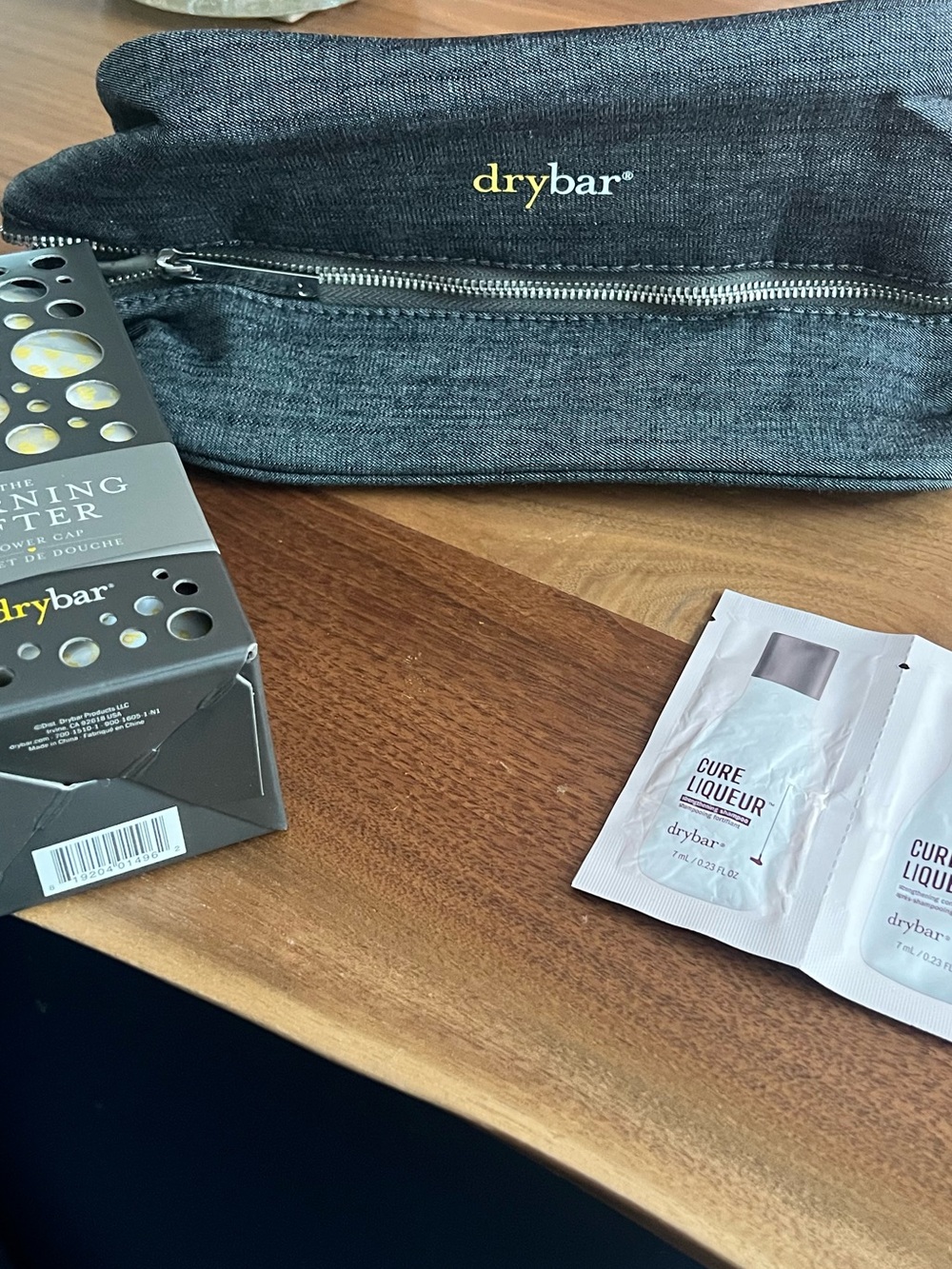 DryBar Accessories. Gray Travel Case with Cure Liqueur Sachets and shower cap.